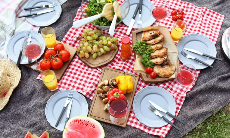 Picnic estivo con anguria, pomodori, uva, verdure e succhi: alimentazione estiva per stare leggeri e idratati